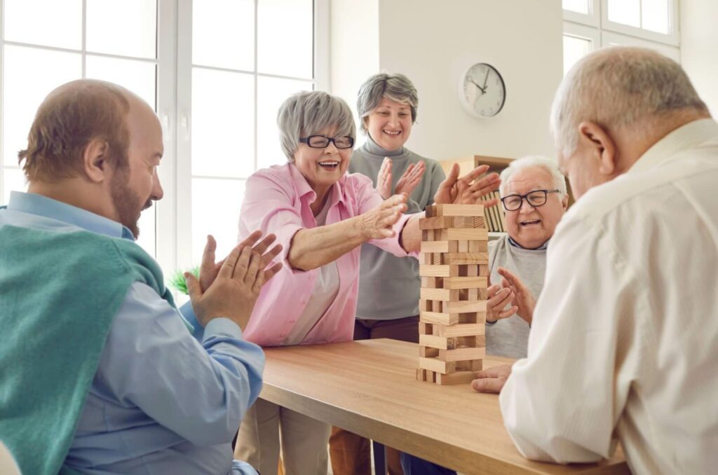 A group of seniors enjoying a table-top game together during their stay at a short-term care community.