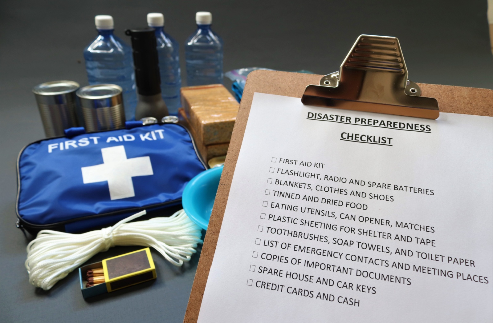 A clipboard labelled "Disaster Preparedness Checklist" with hurricane preparation items in the background.